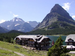 many glacier lodge with mountains and lake in background